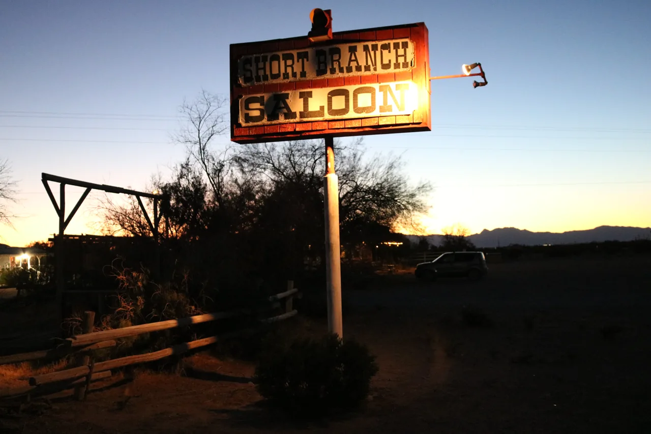 The illuminated saloon sign against the evening sky
